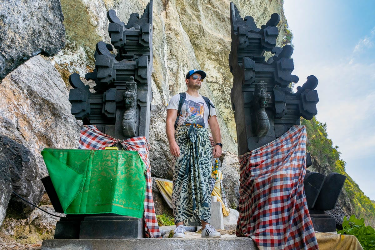 Boy in a sarong standing at a temple at Peguyangan Waterfall, Nusa Penida