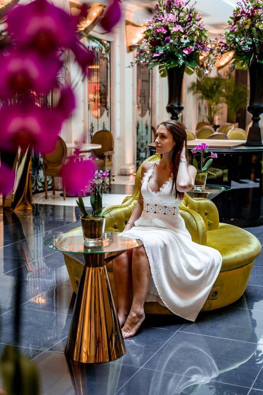 Girl in a white dress sitting in the lobby at the Aria Hotel in Budapest