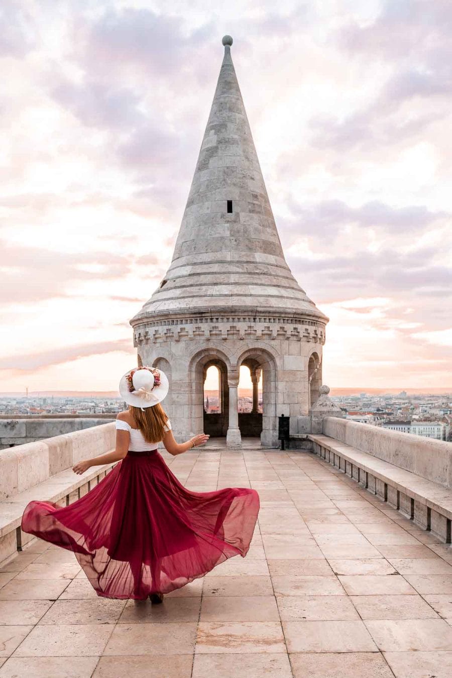 Girl in a red skirt twirling at the upper turrets in Fisherman's Bastion in Budapest