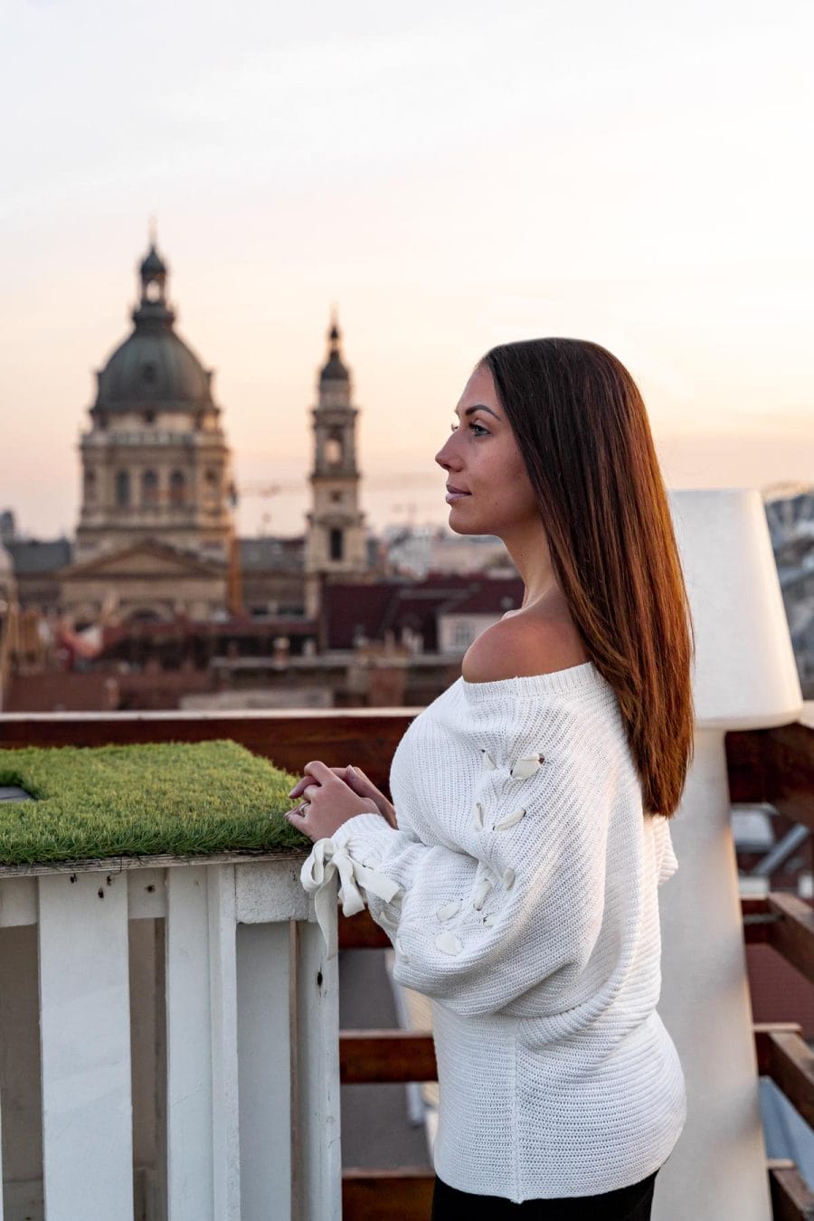 Girl in a white sweater standing at the Intermezzo Roof Terrace, looking at the St. Stephen's Basilica