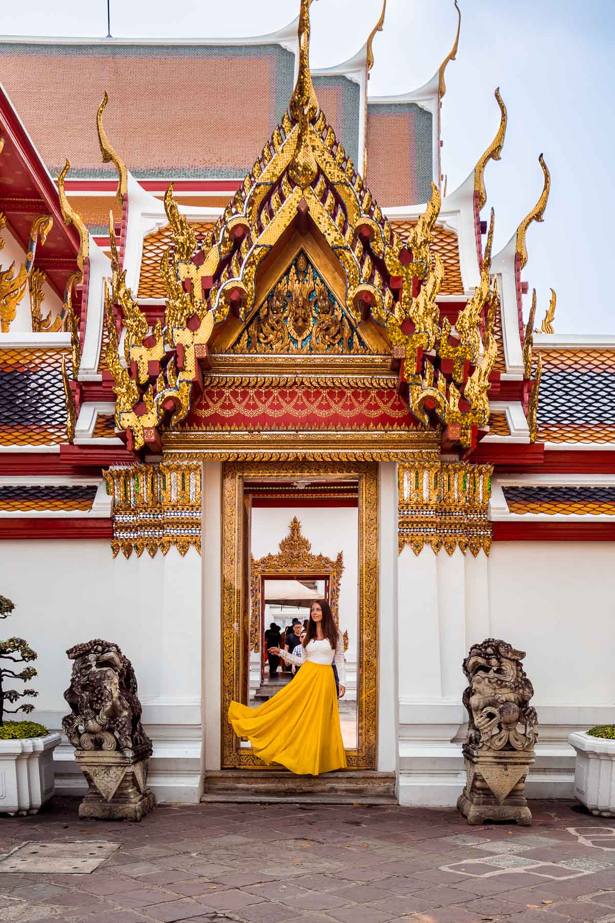Girl in a yellow dress standing inside the Wat Pho in Bangkok