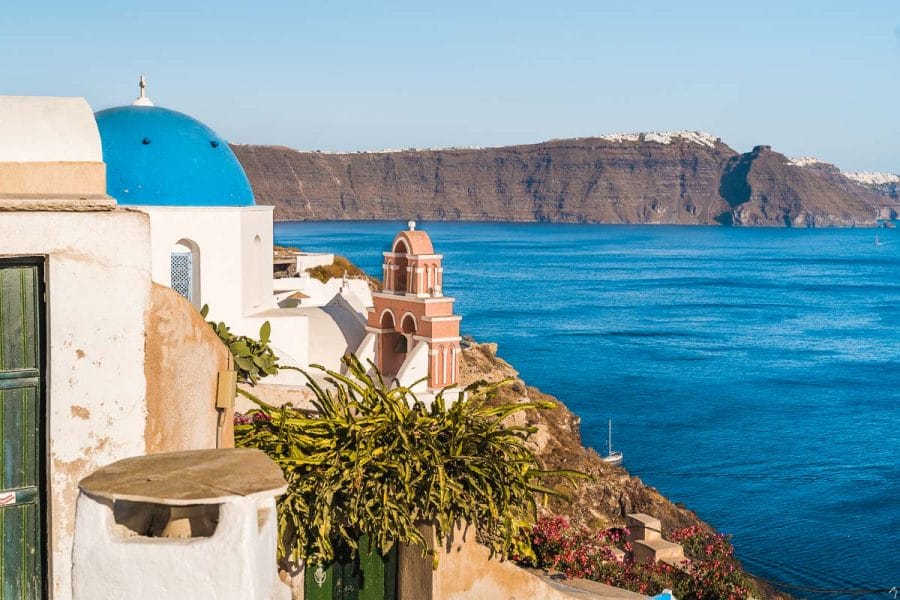 View of the blue sea and a blue domed church in Oia, Santorini