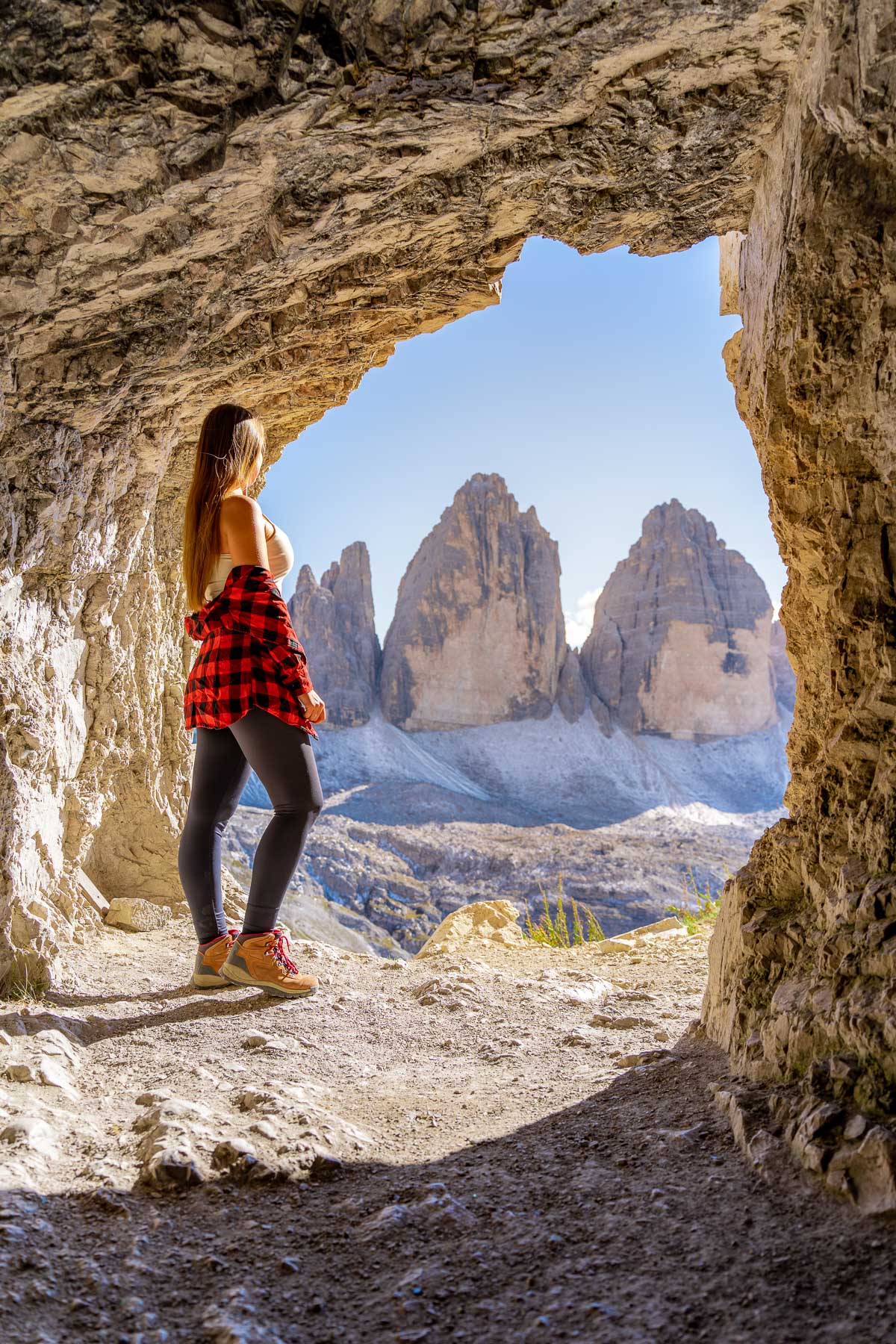 Girl in a cave overlooking Tre Cime di Lavaredo
