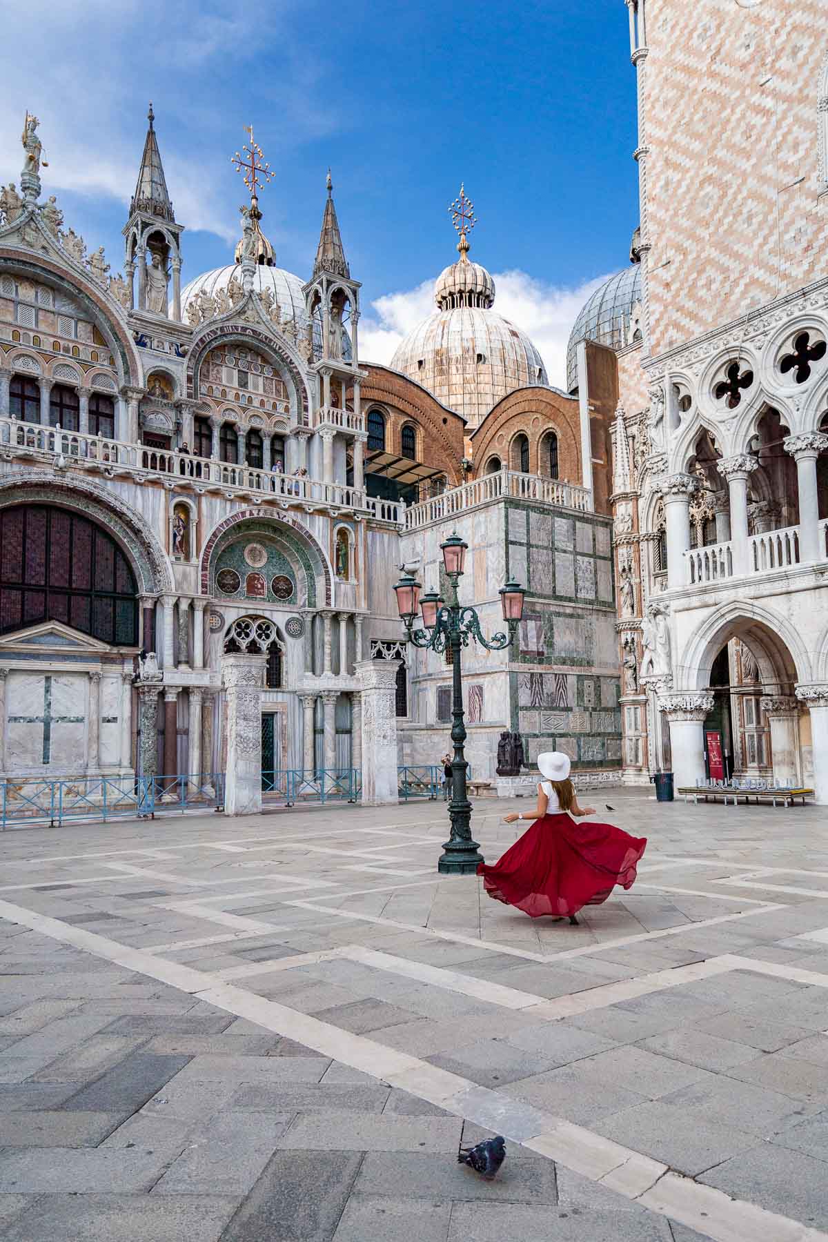 Girl in a red skirt twirling in St. Mark's Square in Venice, Italy