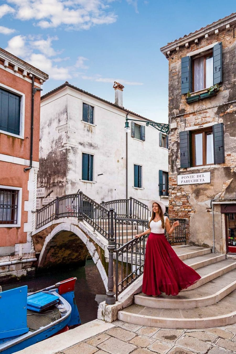Girl in a red skirt standing on Ponte Del Parucheta in Venice