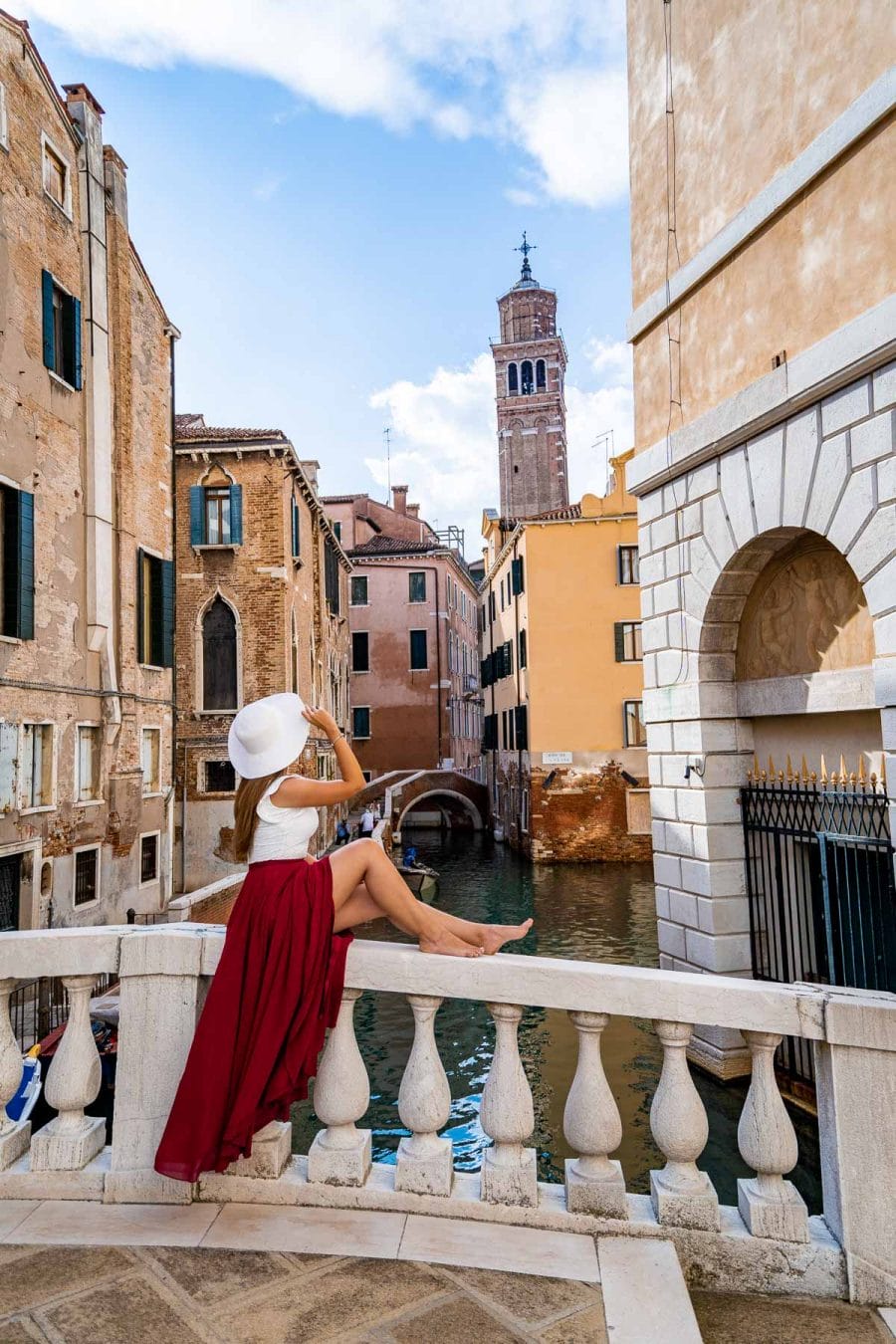 Girl in a red skirt sitting on Ponte Maria Callas in Venice