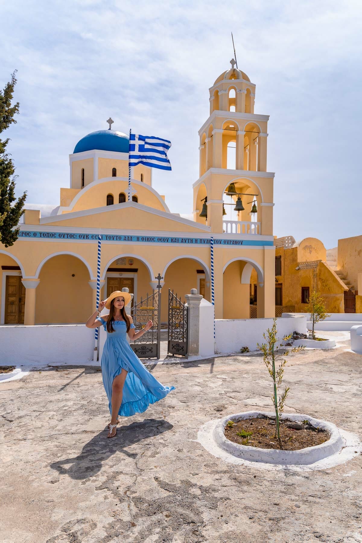 Girl in blue dress in front of Saint Georgios Oia Holy Orthodox Church