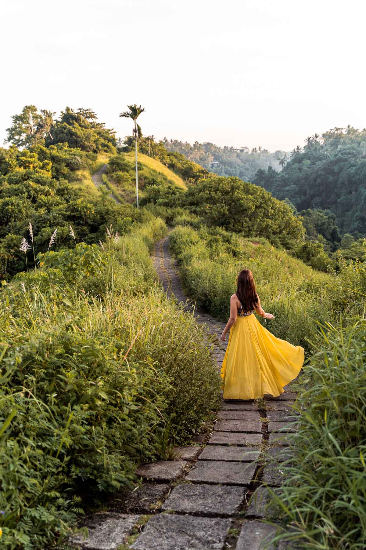 Girl in a yellow skirt walking along the Campuhan Ridge Walk in Ubud, Bali