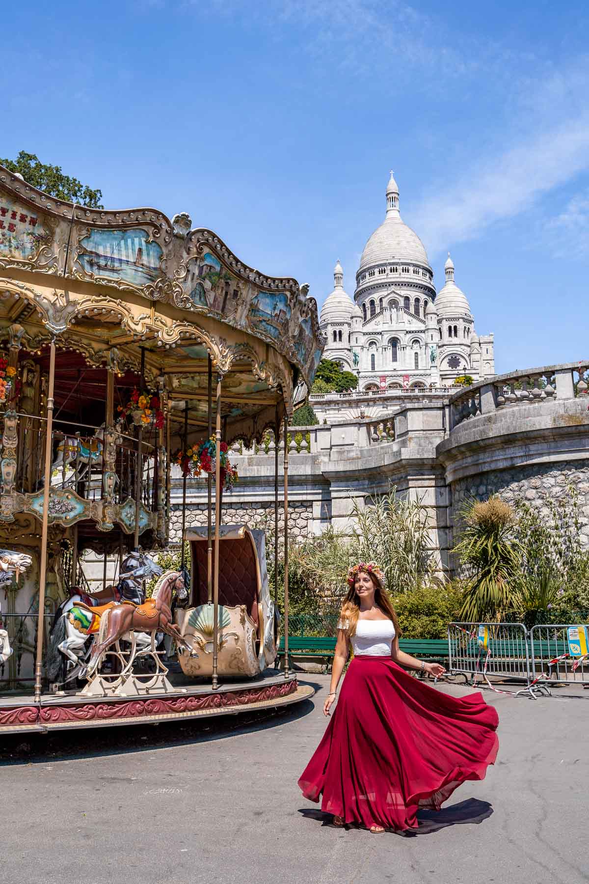 Girl in a red skirt twirling in front of Carrousel de Saint-Pierre in Montmartre, Paris