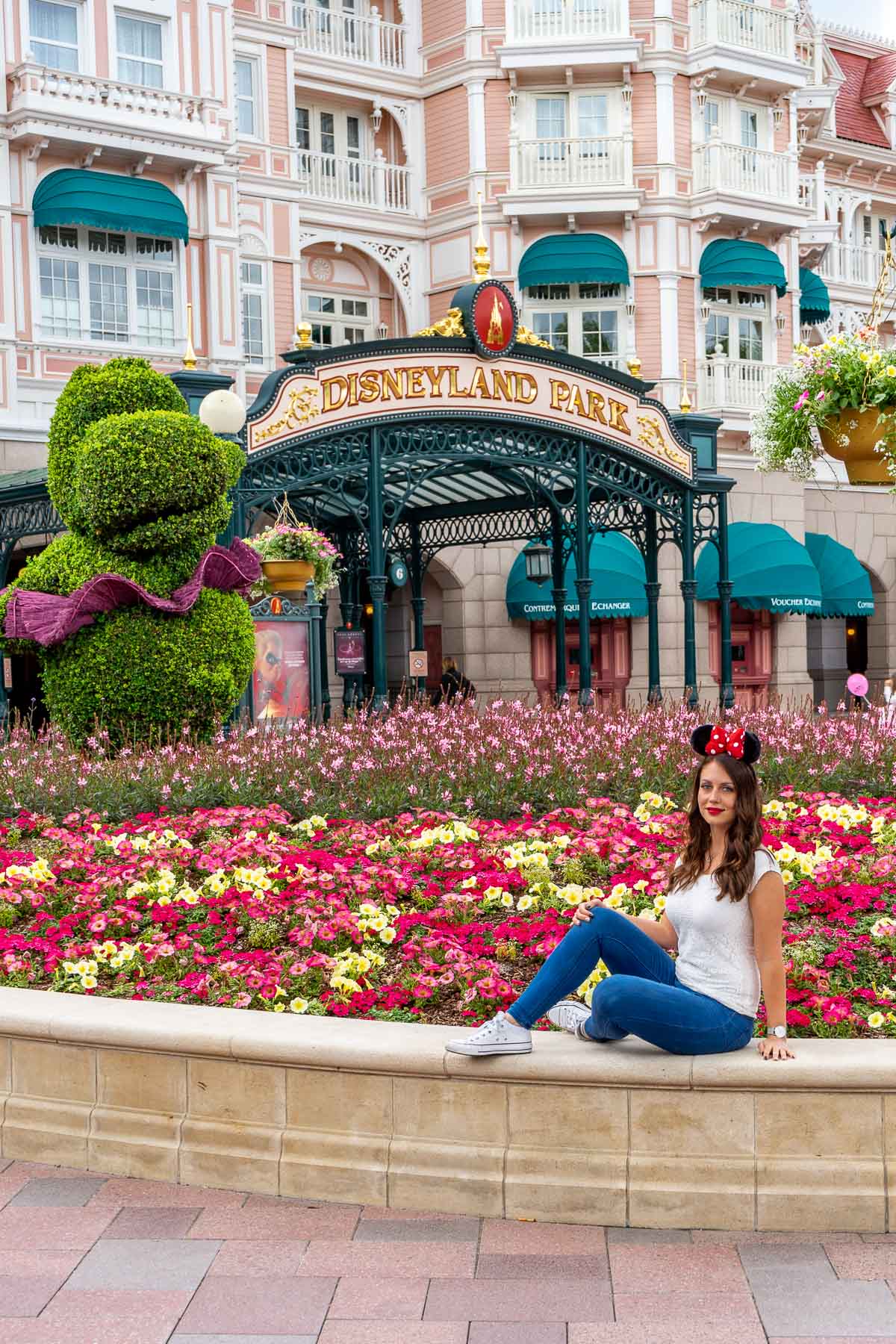 Girl sitting in front of the entrance of Disneyland Paris