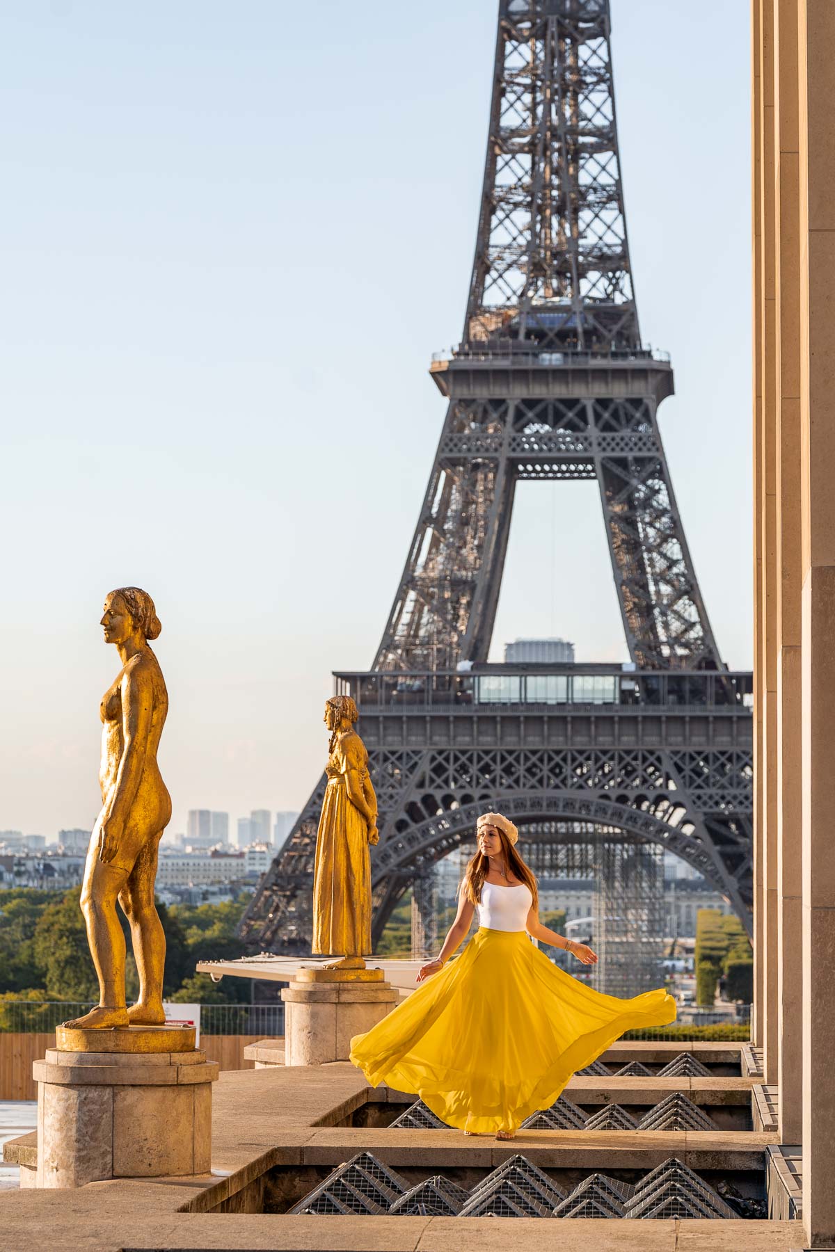 Girl in a yellow dress twirling in front of the Eiffel Tower at Trocadero, one of the most instagrammable places in Paris