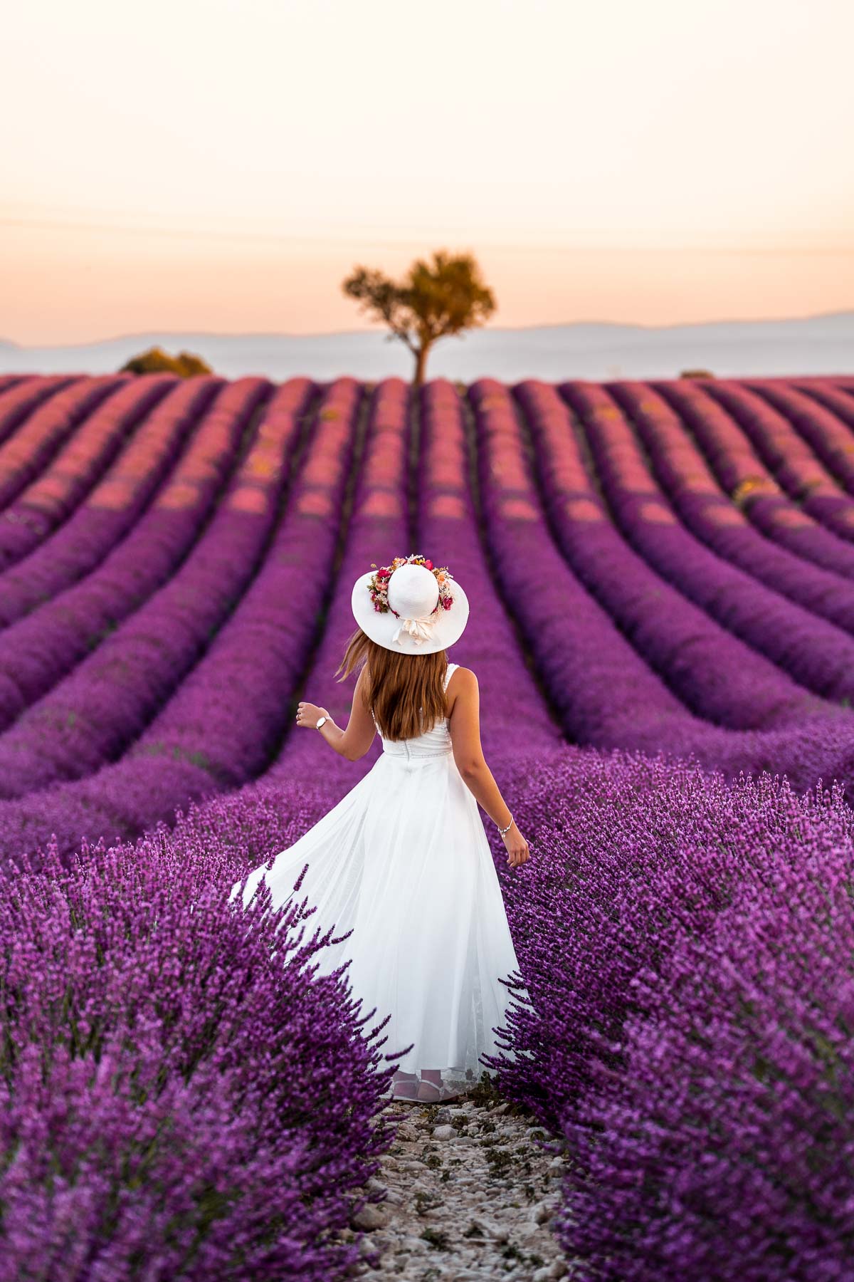 Girl in a white dress twirling in the middle of the lavender fields in Provence