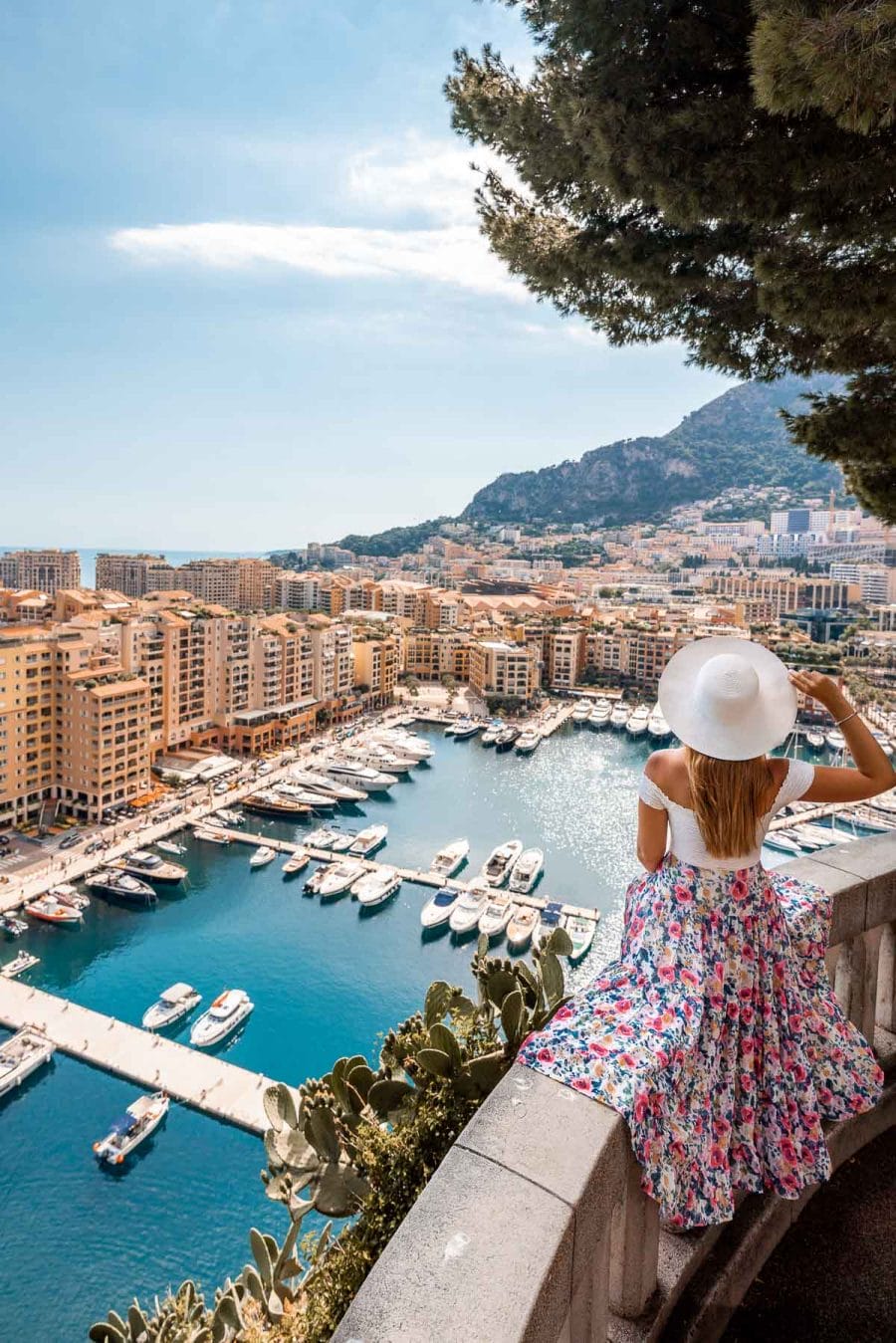 Girl in a floral dress sitting at a viewpoint in Monte Carlo, Monaco