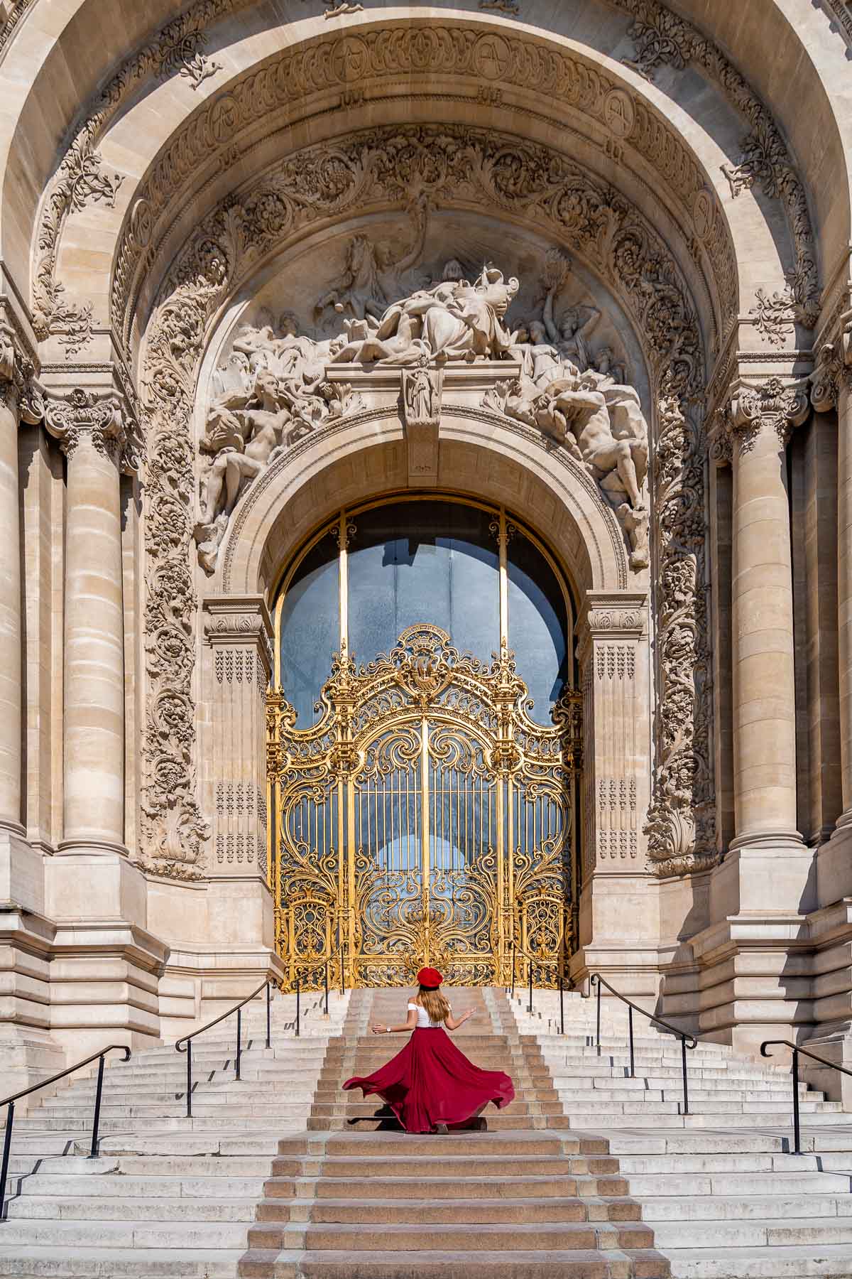 Girl in a red skirt twirling in front of Petit Palais in Paris
