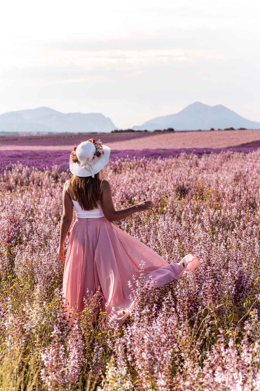 Girl in a pink skirt standing in the middle of a sage field in Provence