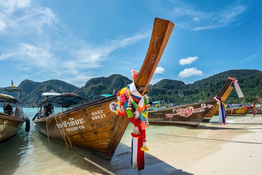 Long-tail boats on a sandy beach in Thailand
