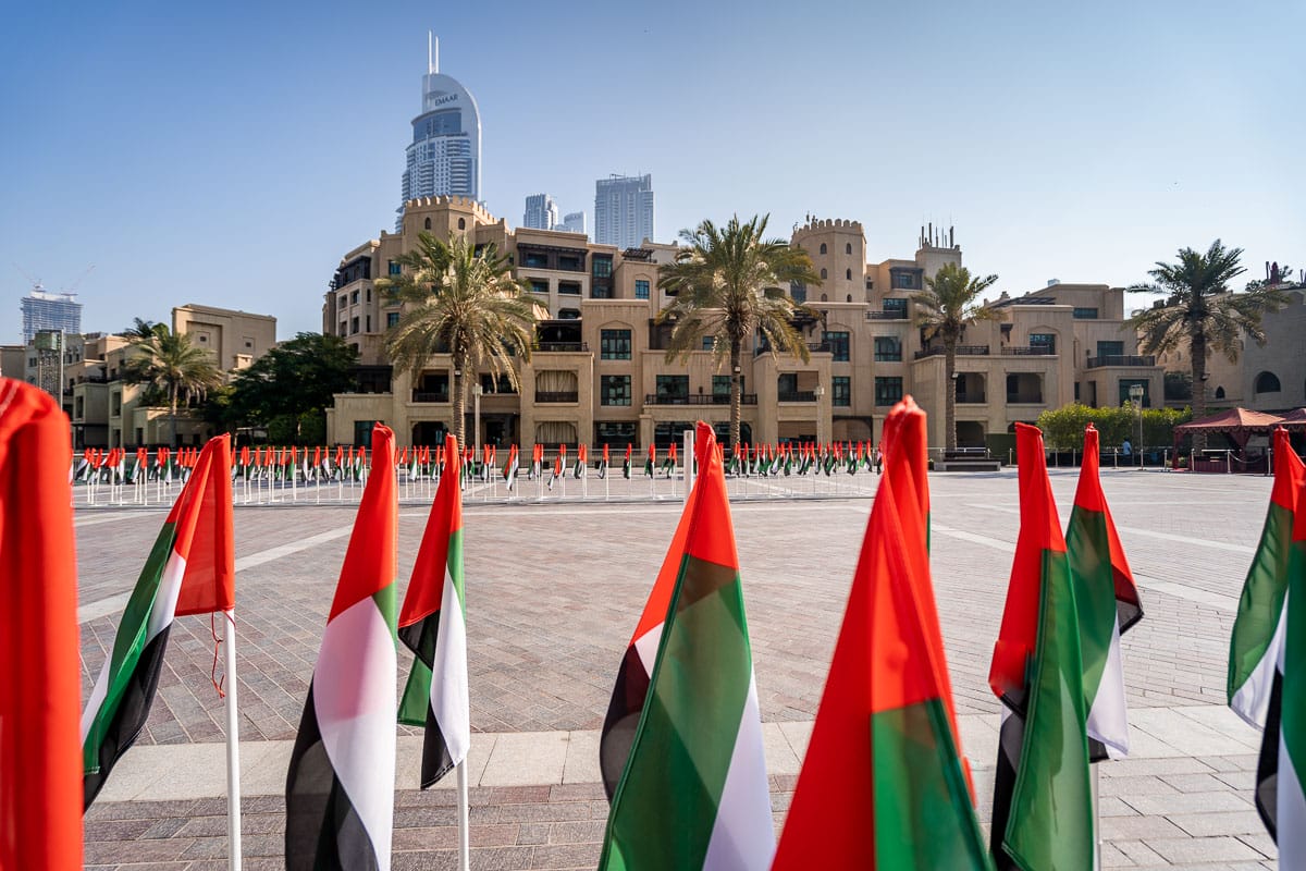 View of Dubai with the United Arab Emirates flag in the foreground