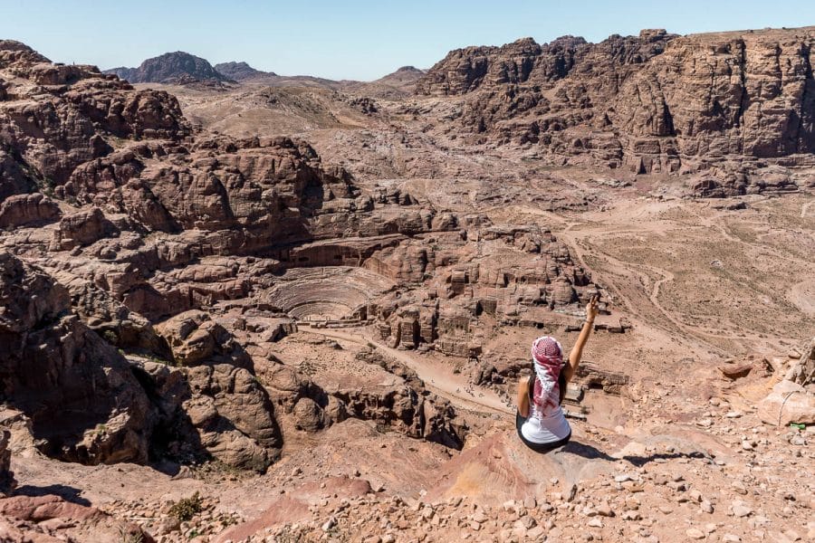 Girl in a white top and a white-red keffiyeh looking at the view in Petra, Jordan