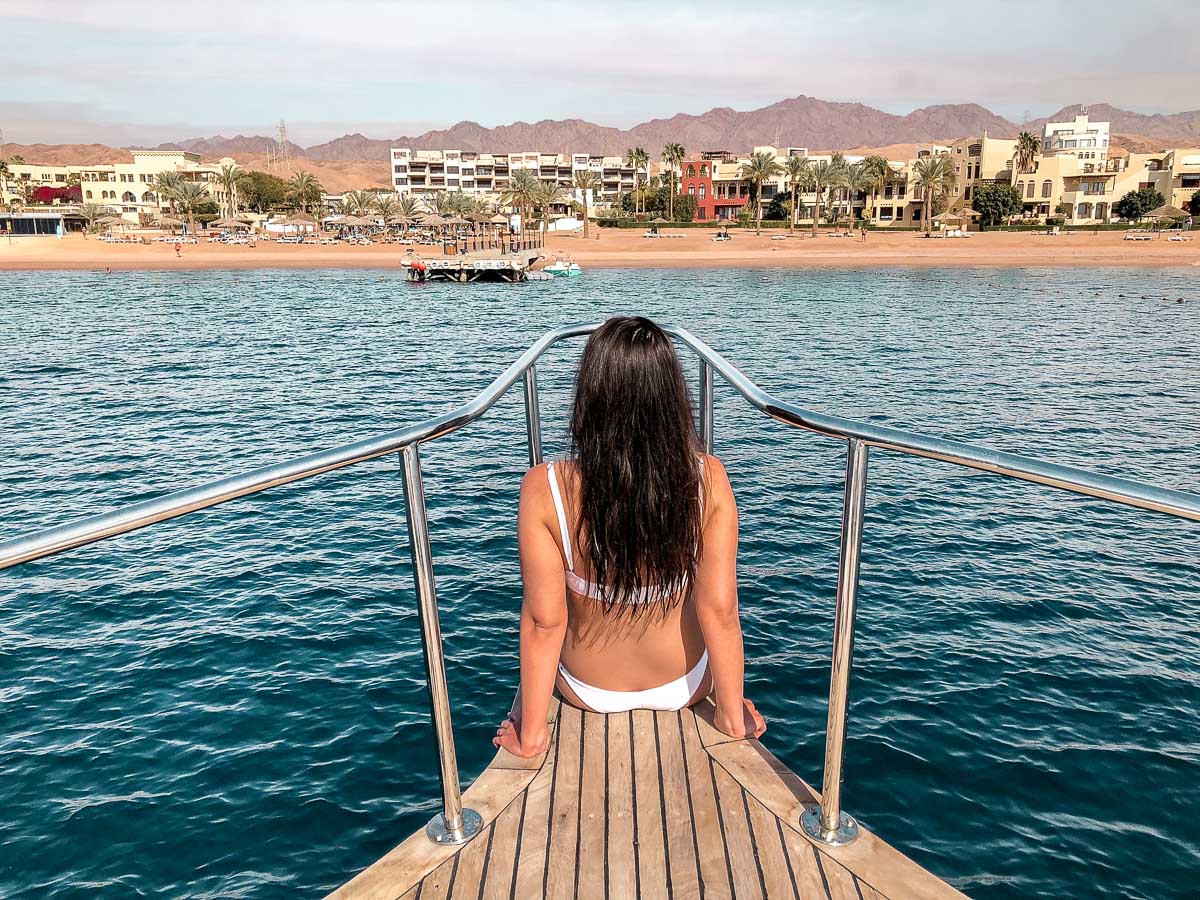 Girl in a white bikini sitting on a snorkeling boat in Aqaba, Jordan