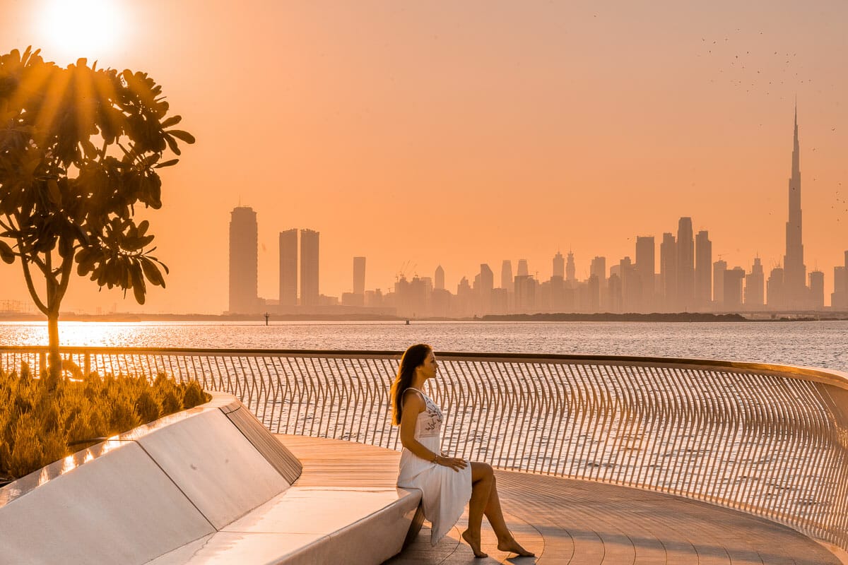 Sunset at Dubai Creek Harbour with girl in a white dress sitting in the middle