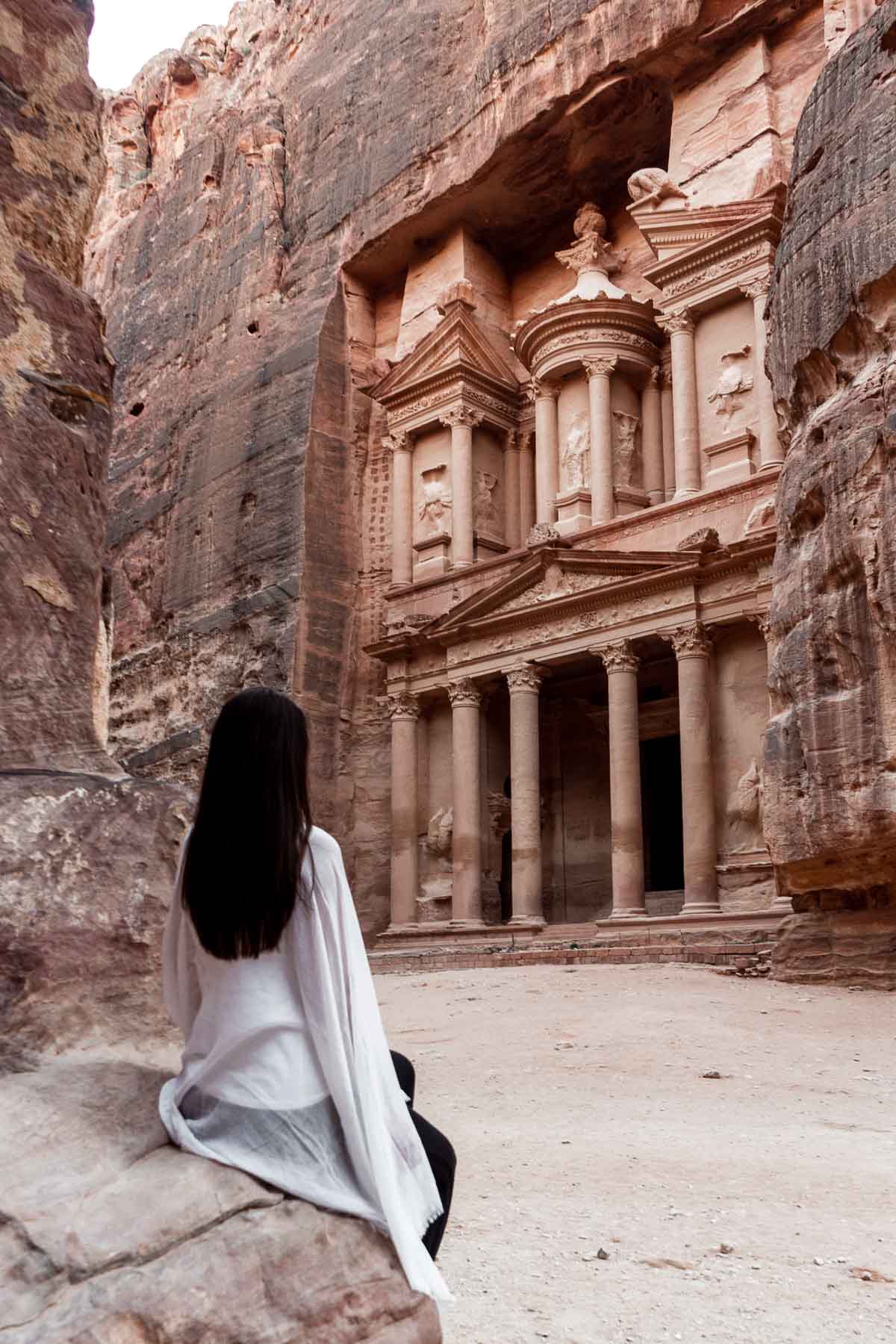 Girl in a white scarf looking at the Treasury in Petra, Jordan