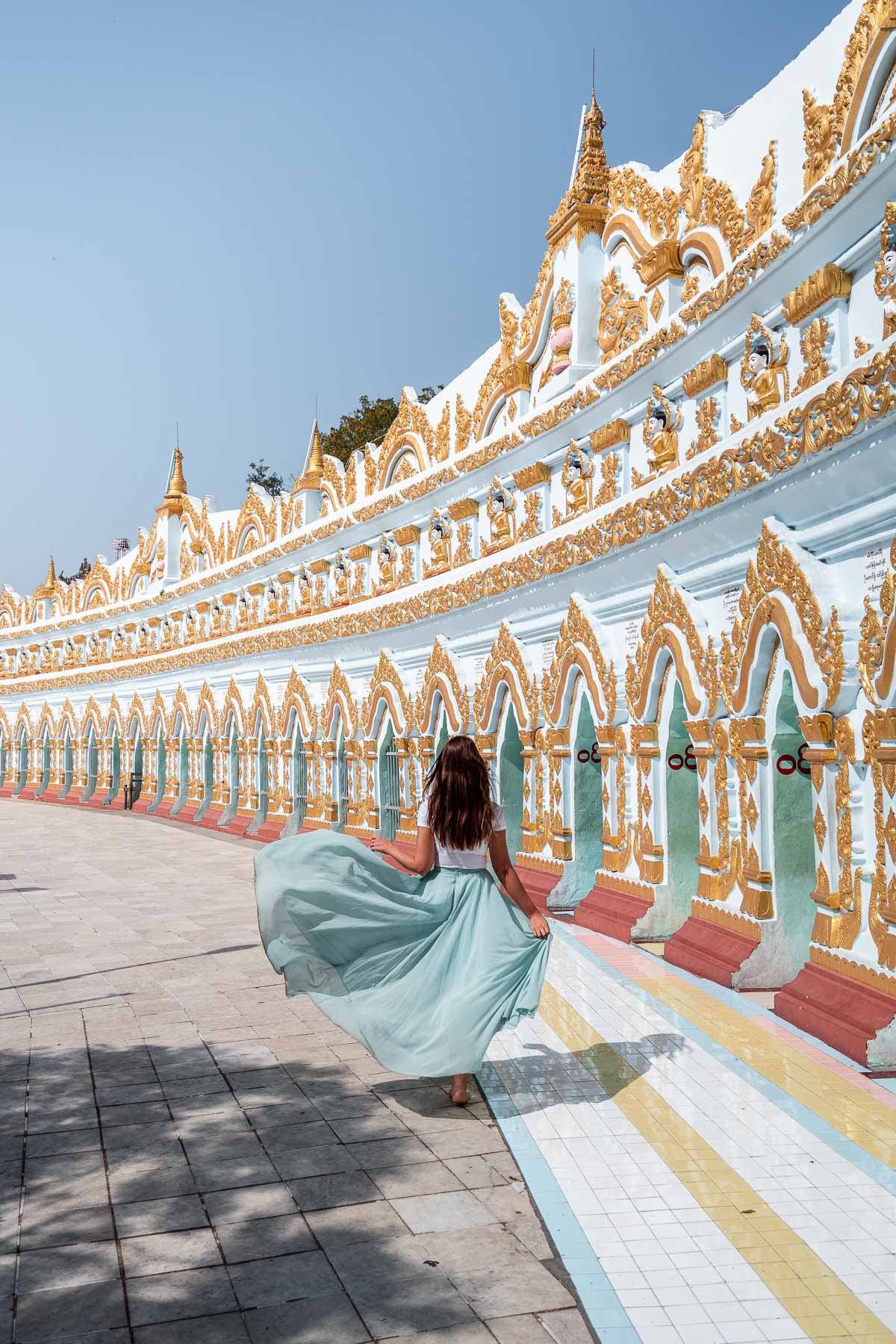 Girl in a pink skirt walking in the U Min Thonze Temple in Myanmar