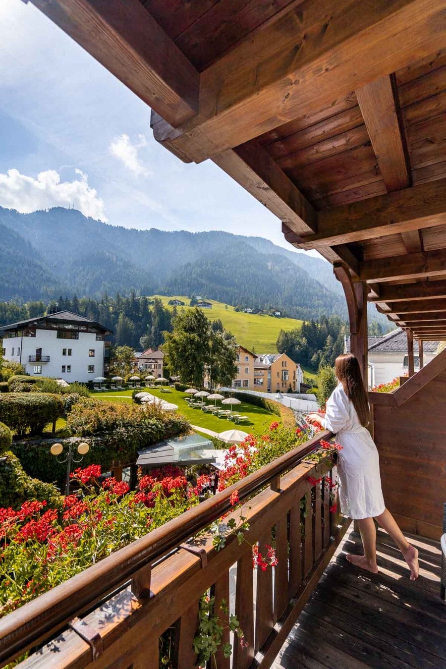Girl in a bathrobe looking at the view from the room at Hotel Angelo Engel in Ortisei, Dolomites