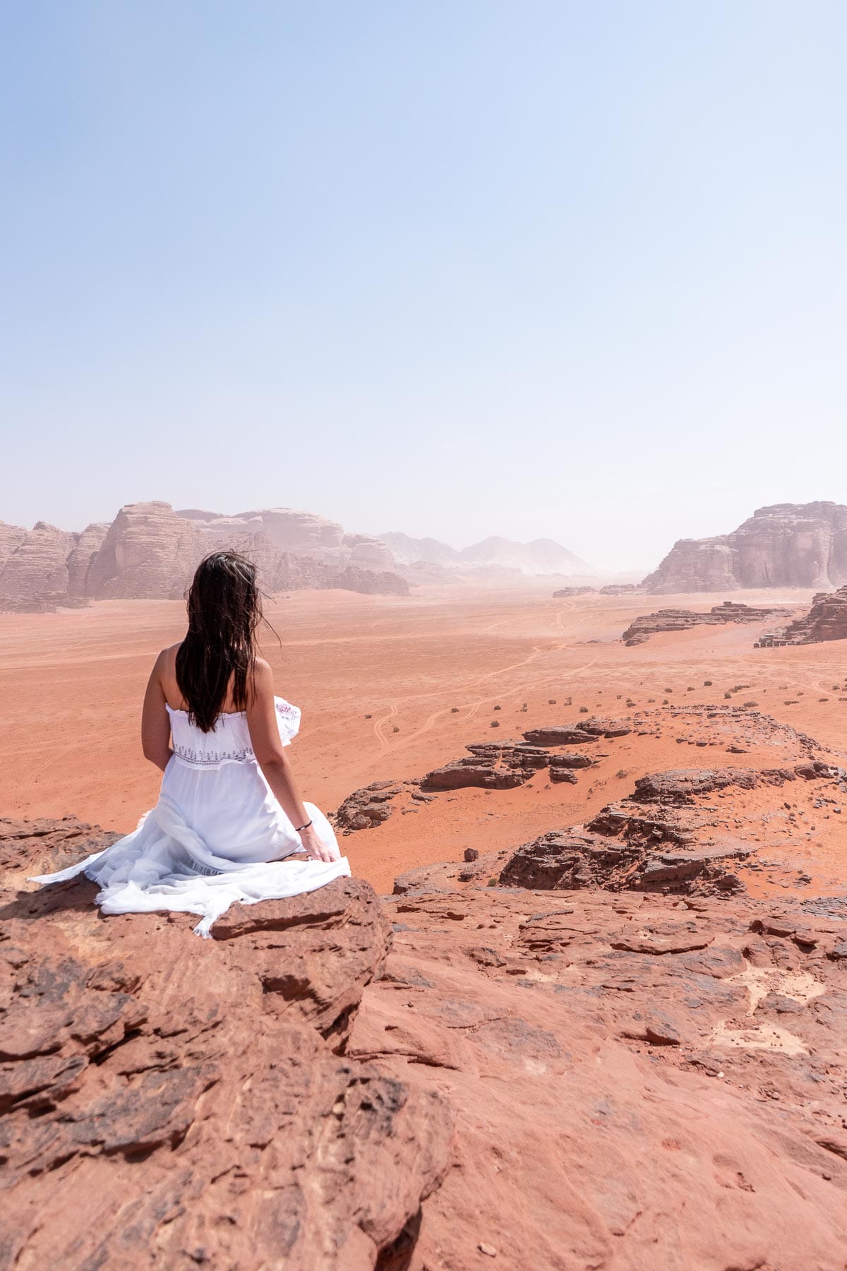 Girl in a white dress looking at the view in the Wadi Rum, Jordan