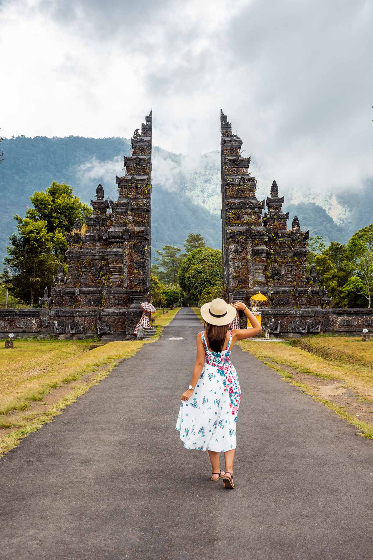 Girl in a floral dress standing in front of the Handara Gate in Bali