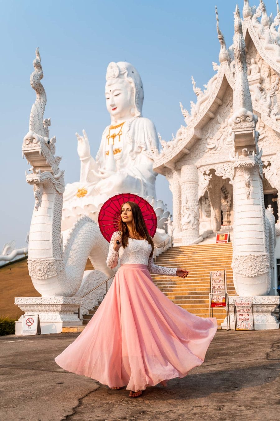 Girl in a pink standing in front of Huay Pla Kang Temple in Chiang Rai