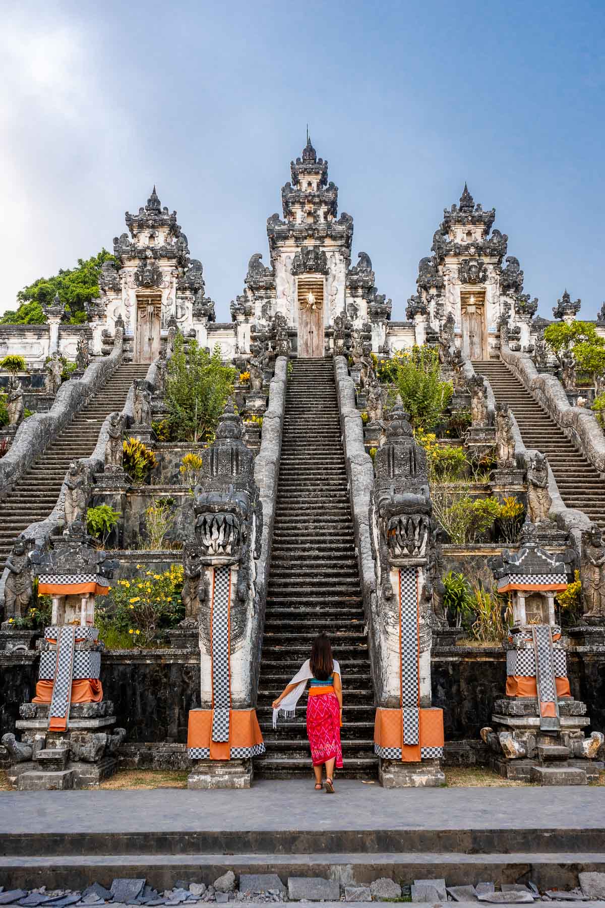 Girl in a pink sarong standing in front of Pura Lempuyang Temple in Bali