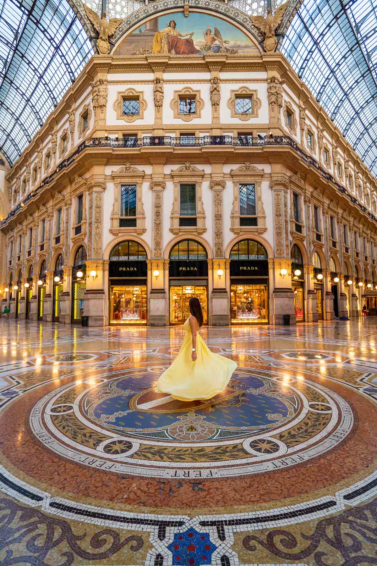 Girl in a yellow dress twirling inside the Galleria Vittorio Emanuele in Milan, Italy