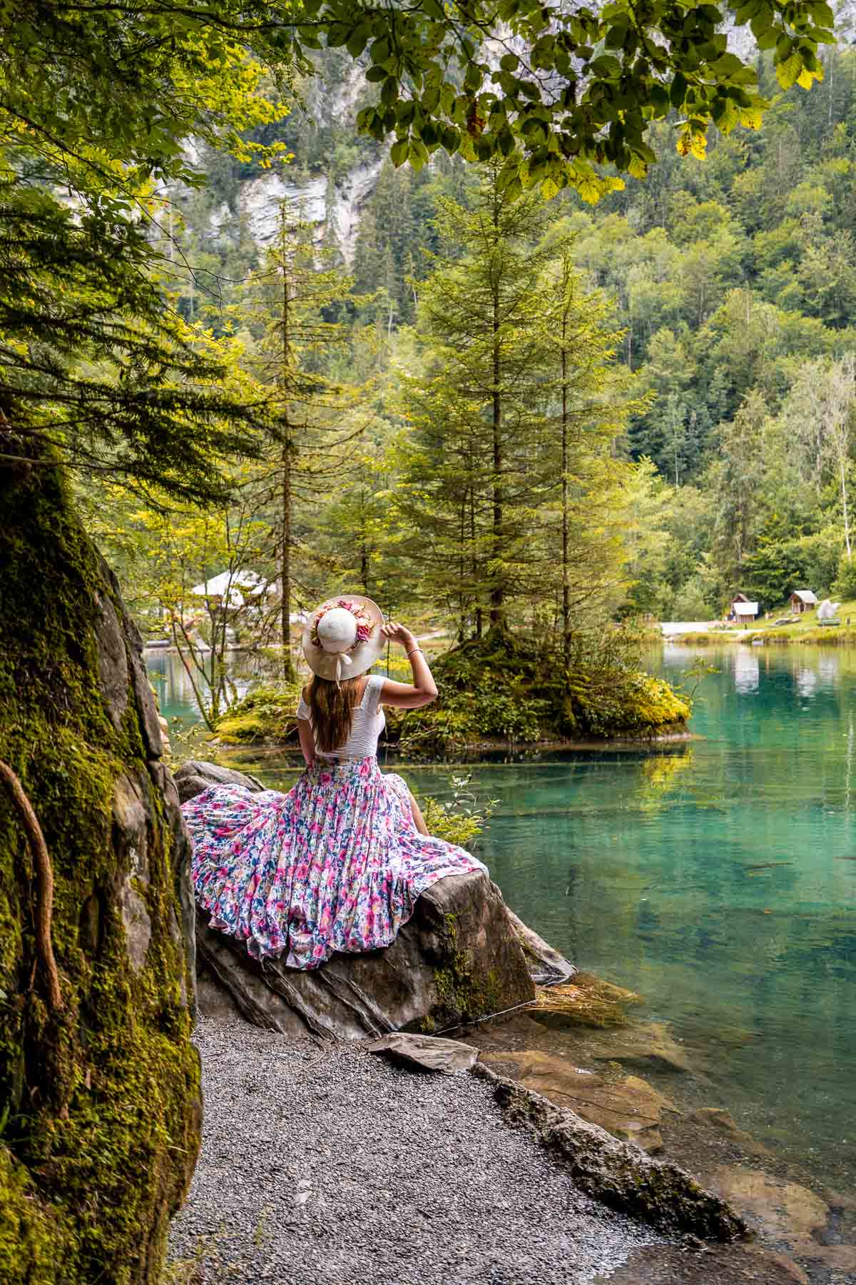 Girl in a purple skirt sitting on a rock at Blausee, Switzerland