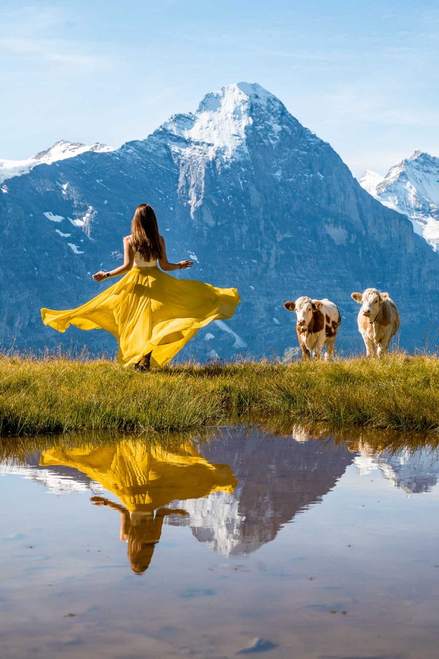 Girl in a yellow dress looking at the mountain panorama at Grindelwald First in Switzerland