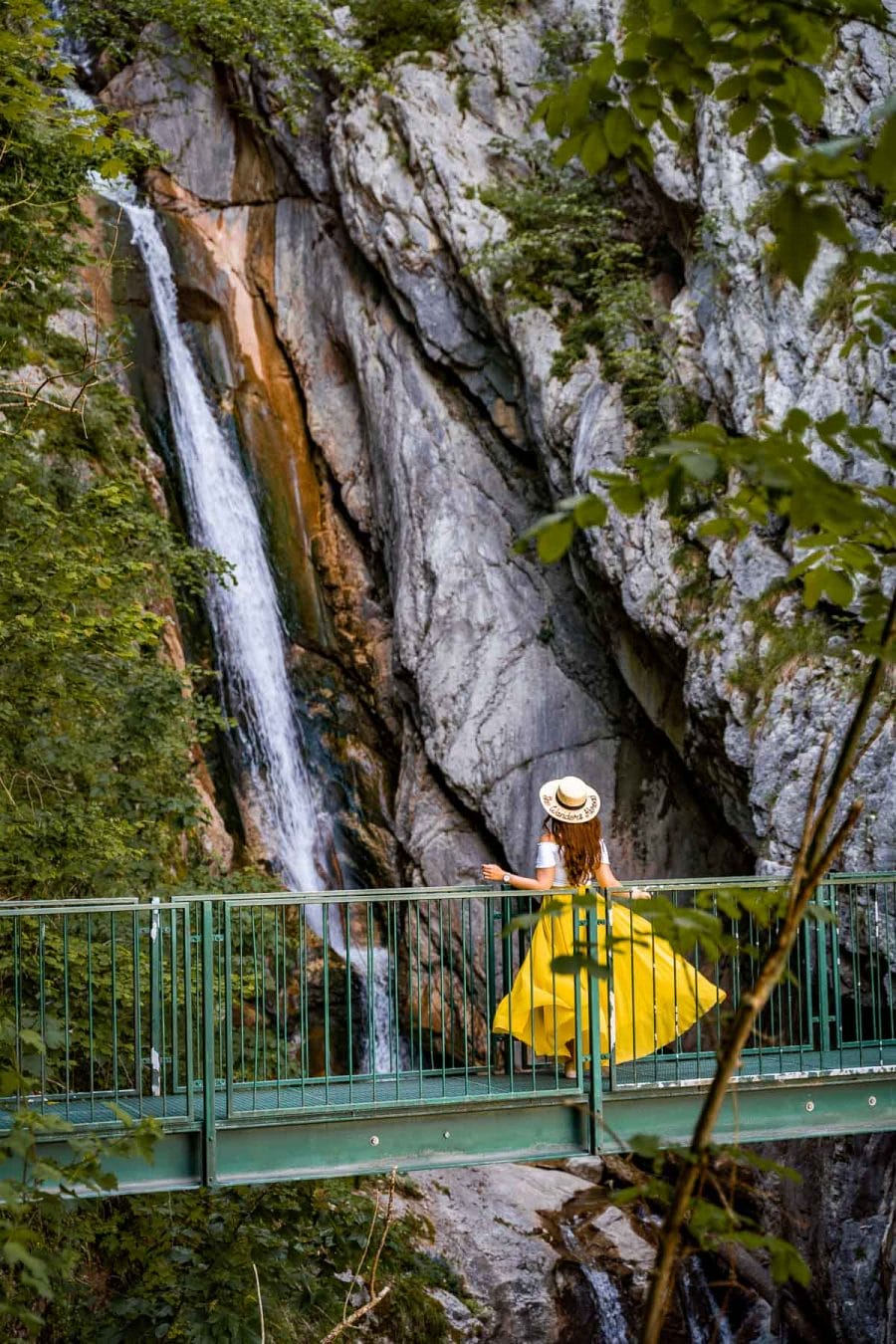 Girl in a yellow dress in front of Hallstatt Waterfall