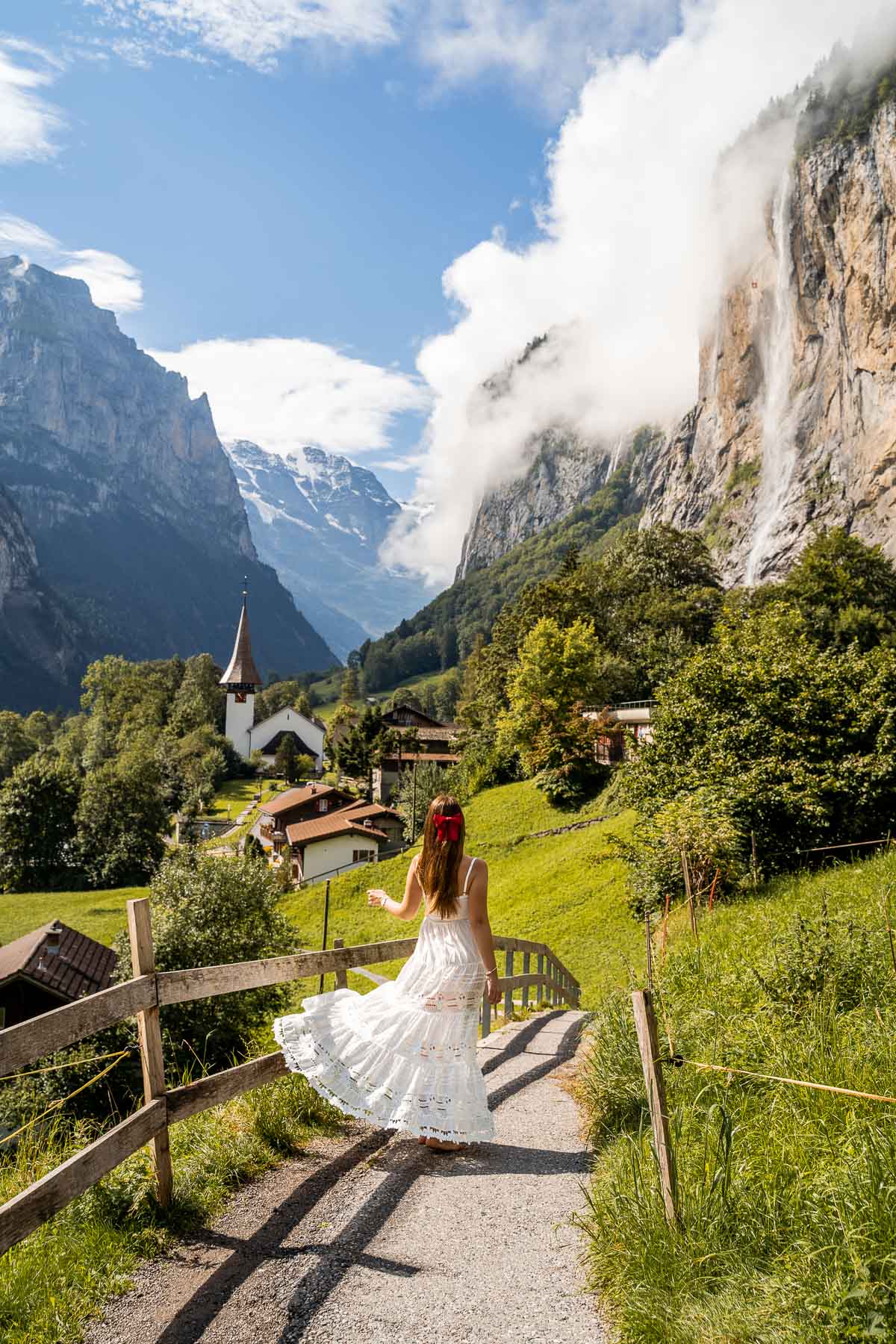 Girl in a white dress twirling in the fairytale town of Lauterbrunnen in Switzerland