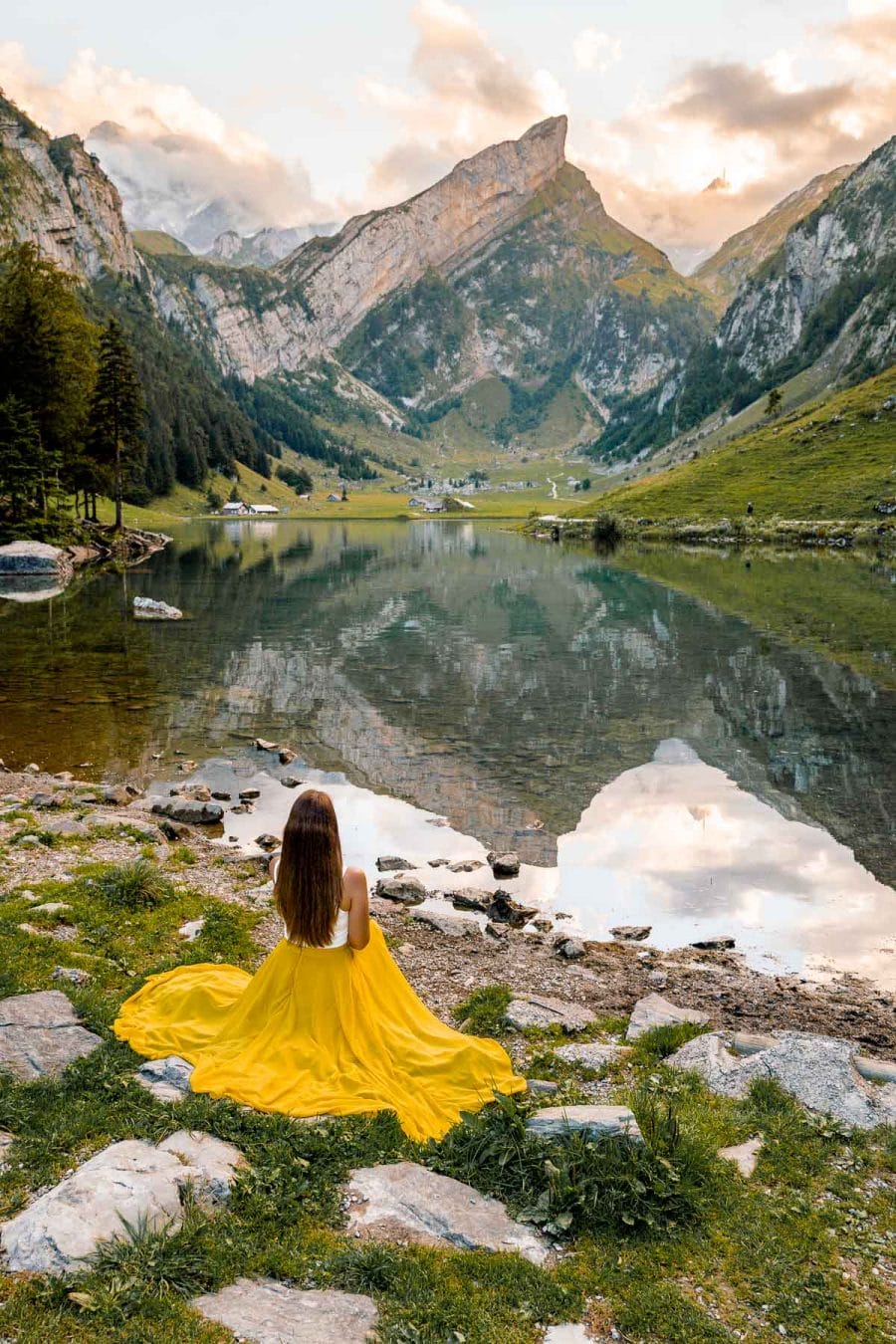 Girl in a yellow dress sitting by Seealpsee, Switzerland
