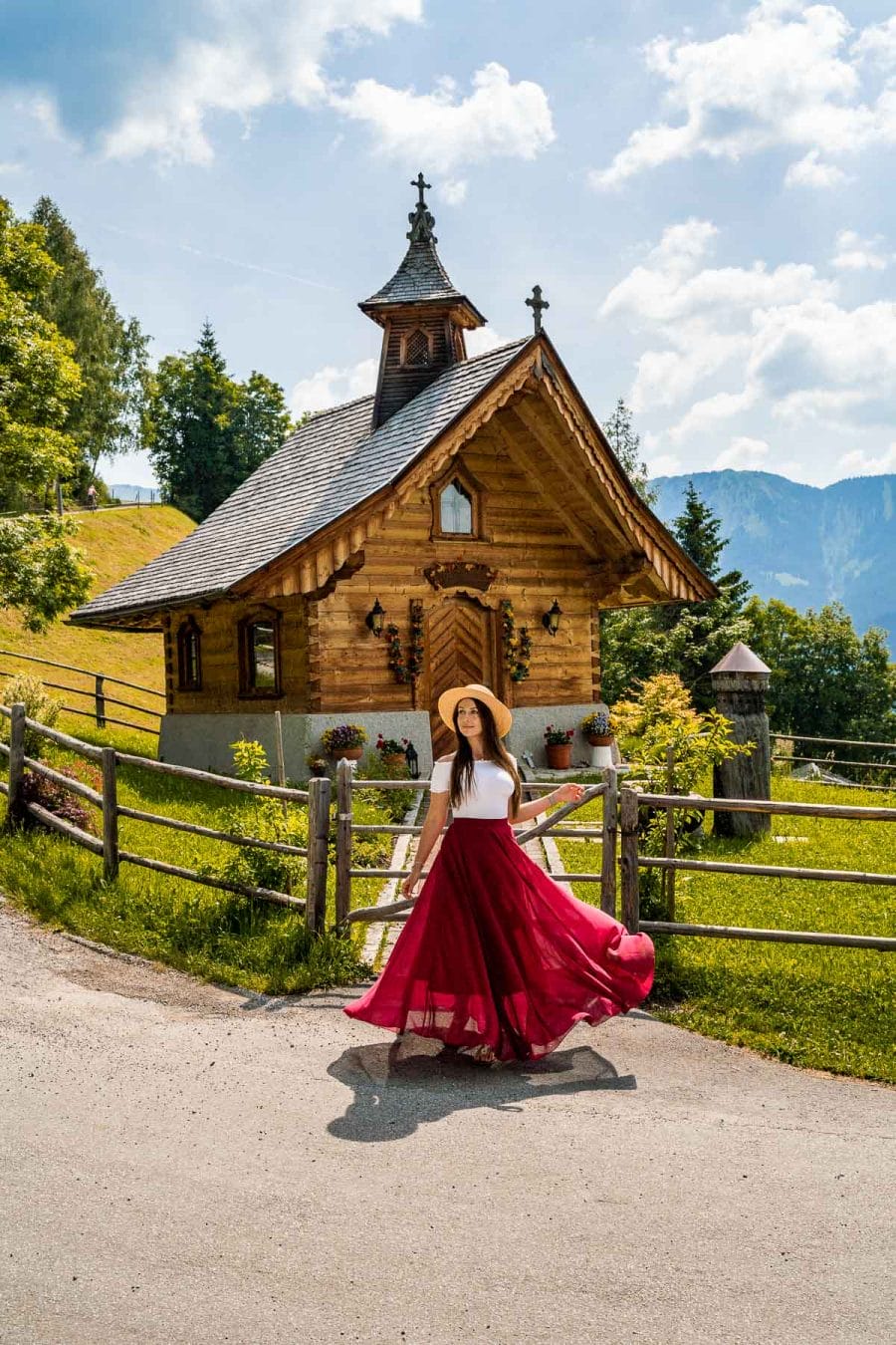 Girl in a red skirt in front of a tiny chapel at Mitterberghof Jausenstation, Austria