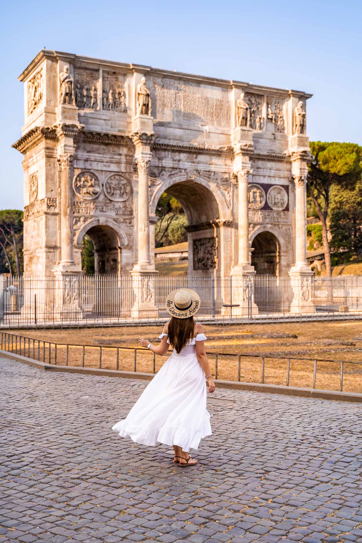 Girl in a white dress in front of Arch of Constantine in Rome, Italy