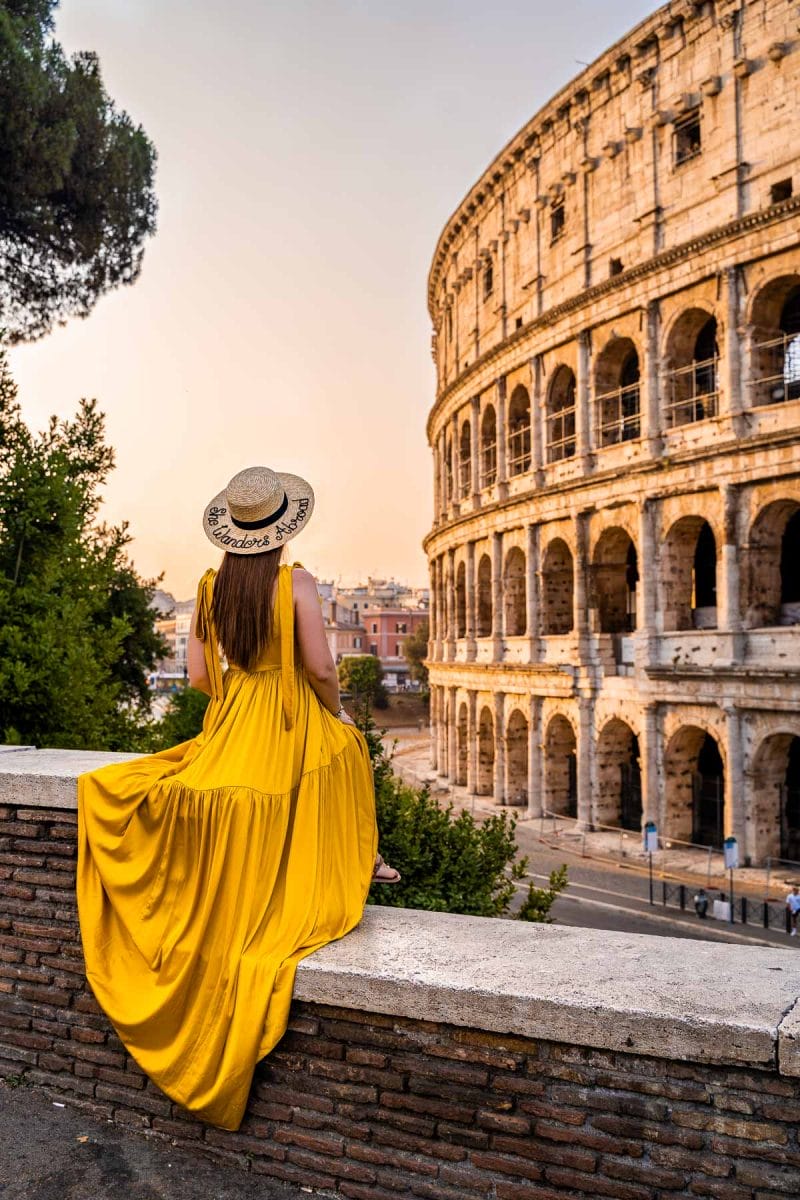 At Sunrise girl in a yellow dress at the Colosseum in Rome, Italy