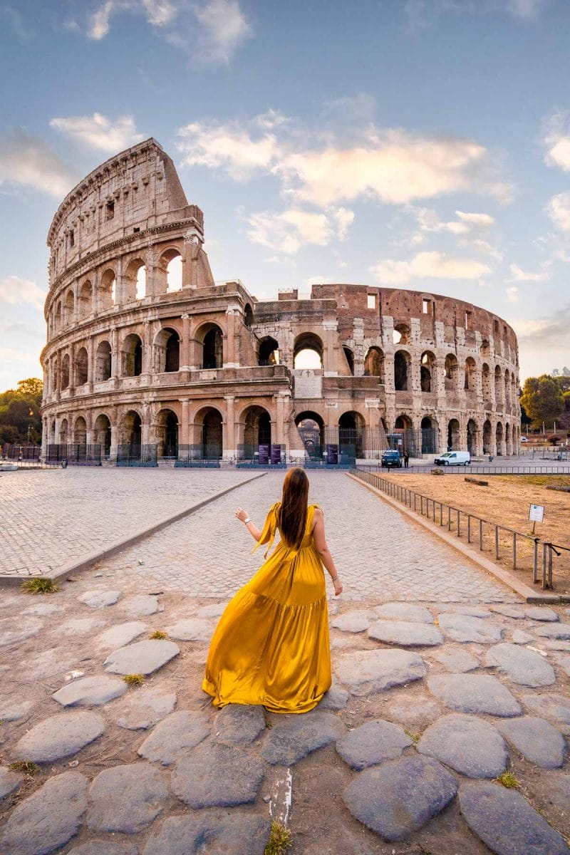 Girl in a yellow dress during sunrise at the Colosseum in Rome, Italy