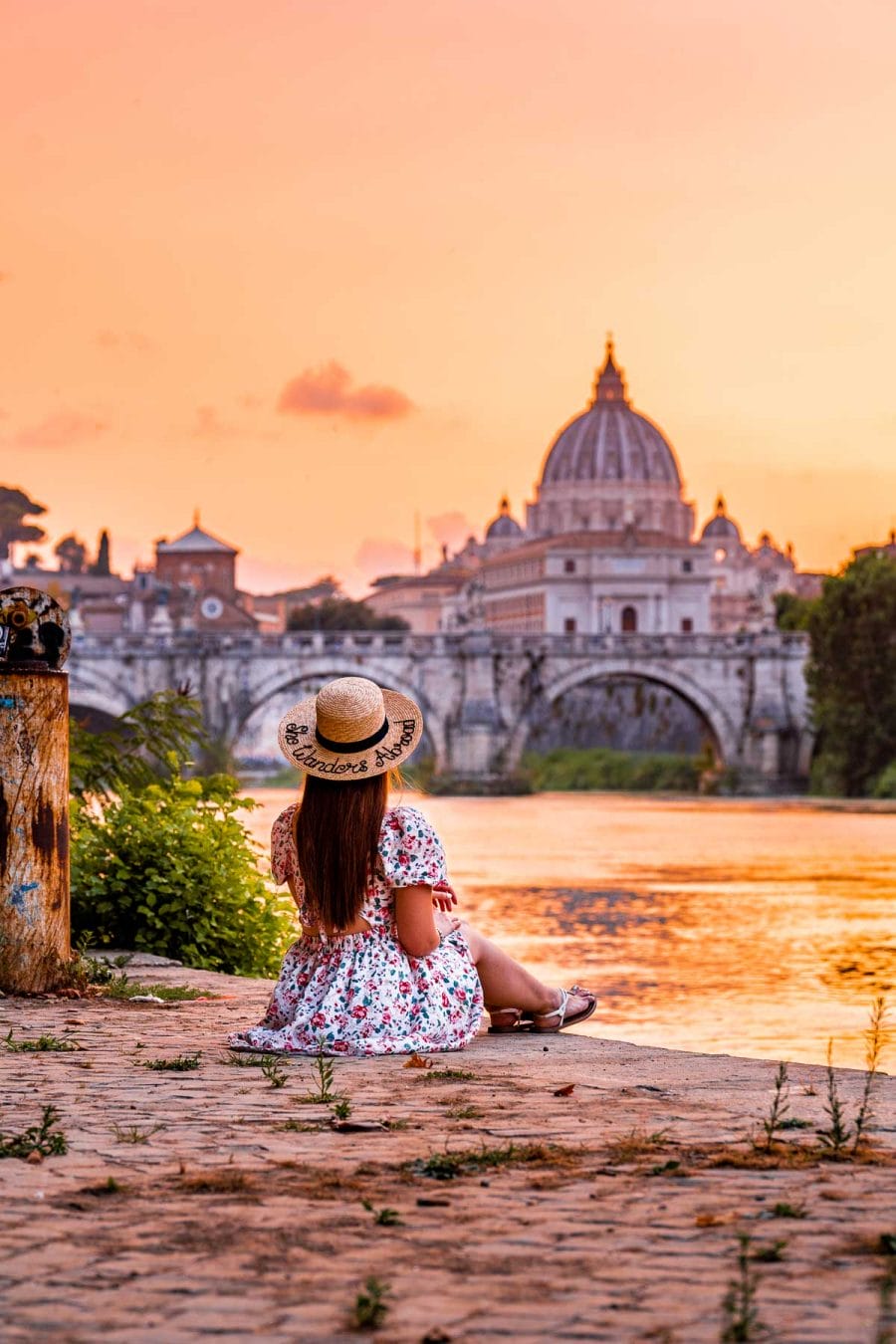 Girl sitting on the shores of River Tiber, watching the sunset in Rome, Italy