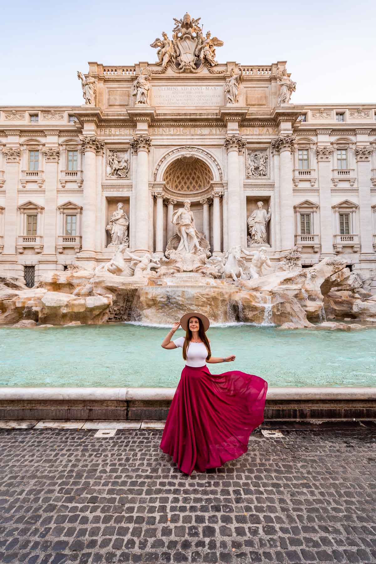 Girl in a red skirt in front of the Trevi Fountain in Rome, Italy