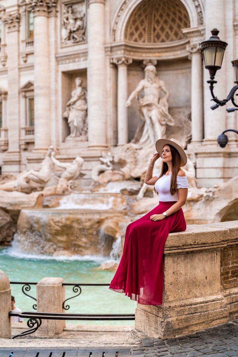 Girl in a red skirt in front of the Trevi Fountain in Rome, Italy