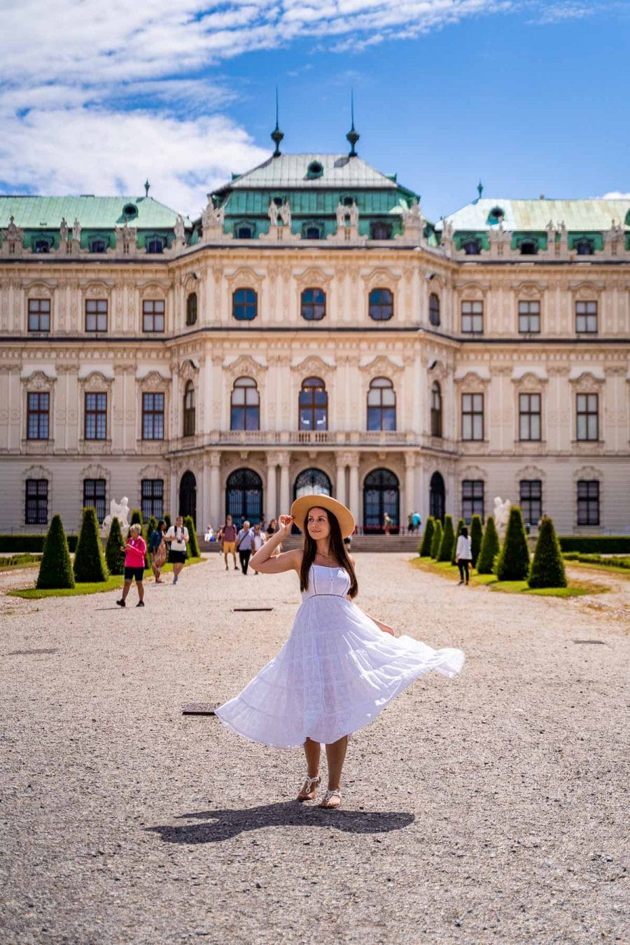 Girl in a white dress in front of Belvedere Palace in Vienna