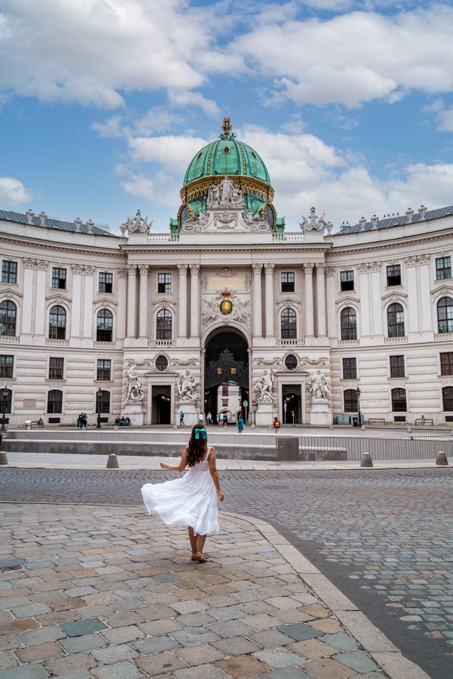 Girl in a white dress in front of the Hofburg in Michaelerplatz, Vienna