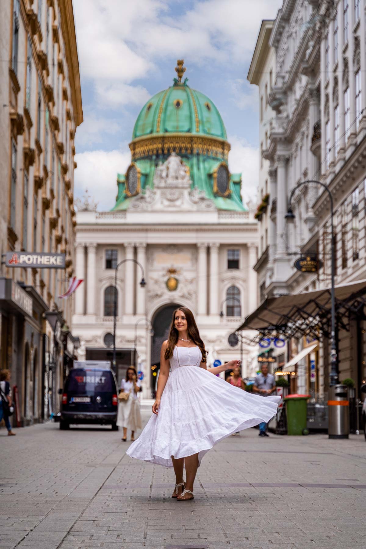 Girl in a white dress with the Hofburg in the background