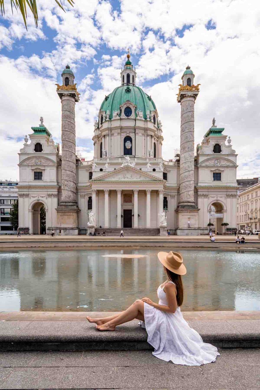 Girl in a white dress sitting in front of Karlskirche, Vienna