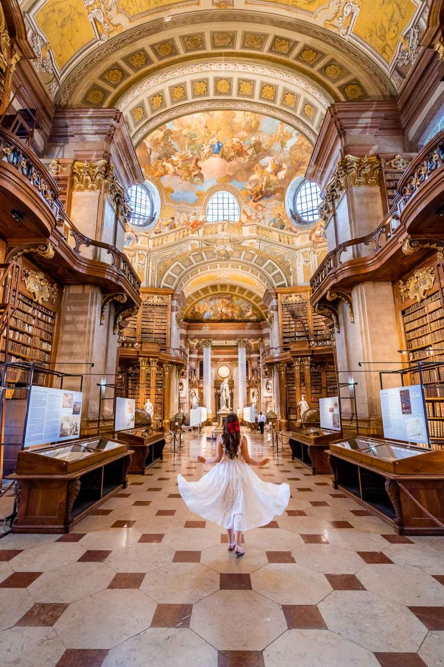Girl in a white dress in the State Hall of the Austrian National Library in Vienna