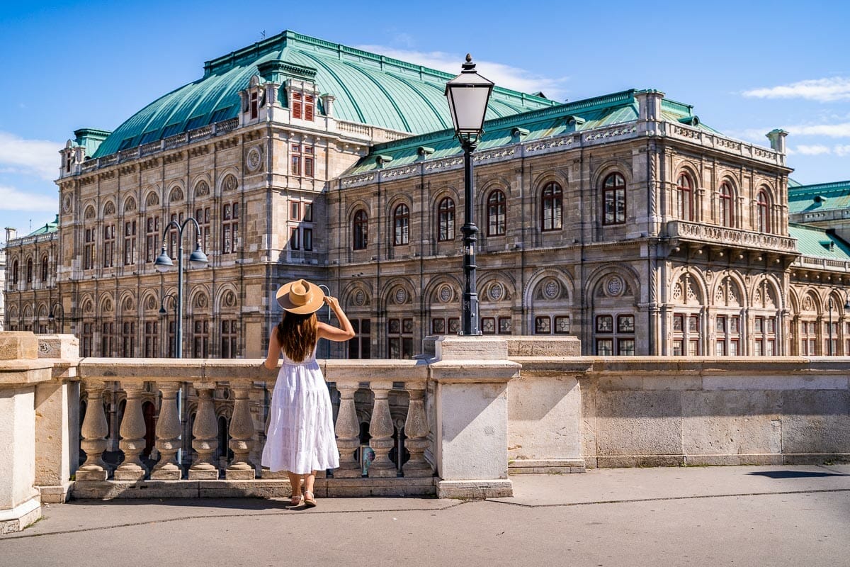 Jente i en hvit kjole foran Wiener Staatsoper
